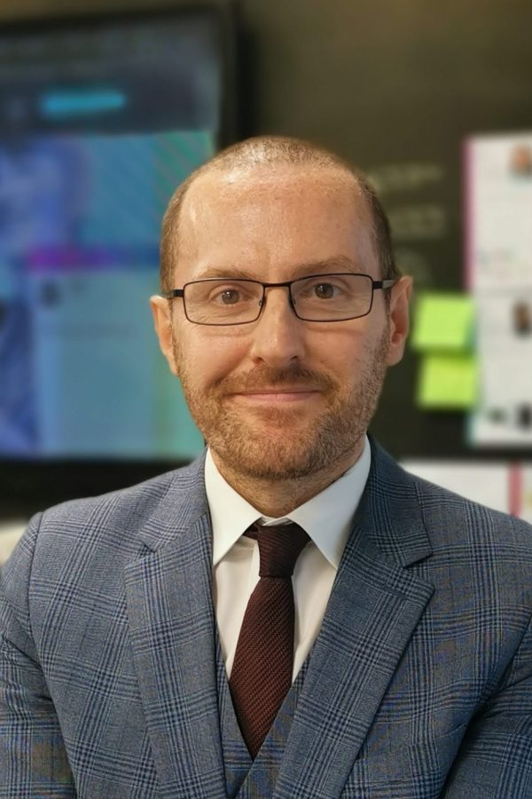 A man in a blue suit and dark red tie