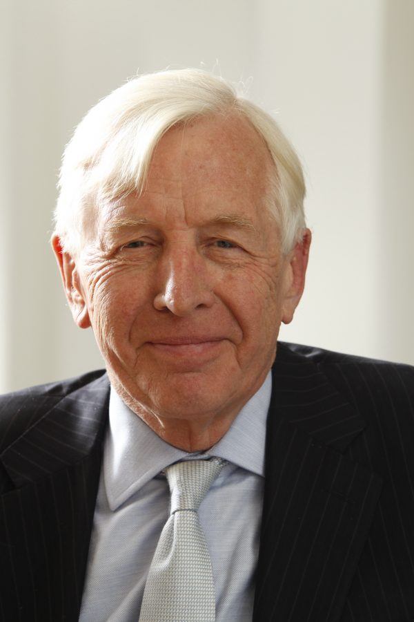 A man with white hair wearing a shirt, jacket and tie