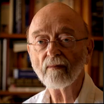 Portrait photograph of a man with a grey beard and glasses