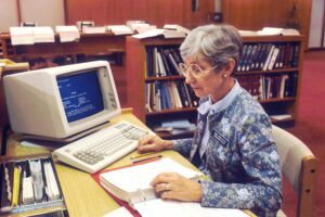 A librarian at the National Library of Medicine (NLM) is using an IBM computer to access PDQ. The Physicians Data Query was designed by the National Cancer Institute to help physicians obtain information about the most up-to-date protocols, physicians, and clinics treating cancer patients. 1987