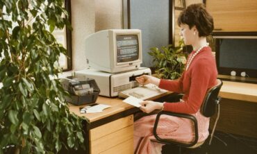 A woman sat at a desk using a PC.