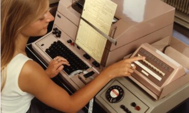 Female using telex broadcast unit. Telex machine; teleprinter receiver and key and lamp switching unit